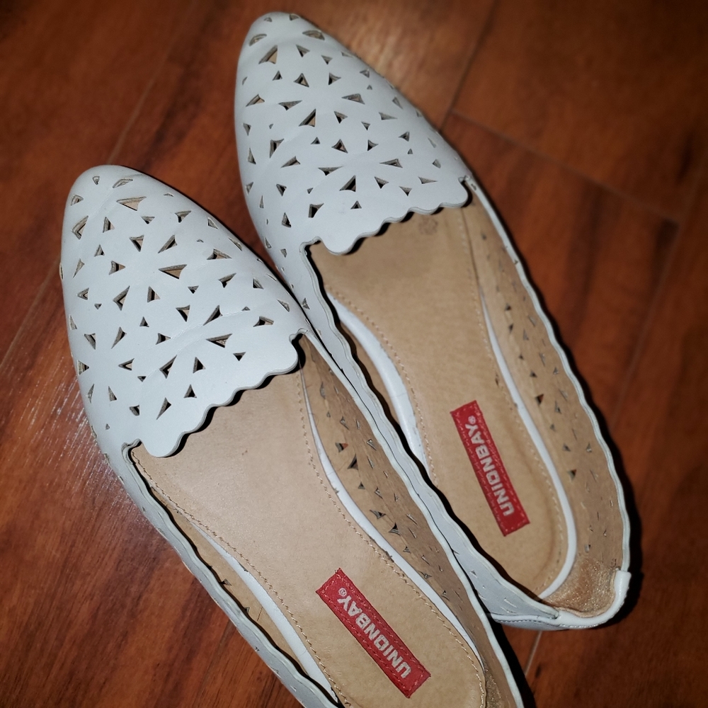 Cream colored flat slip-ons with cut out details. Size 6.5